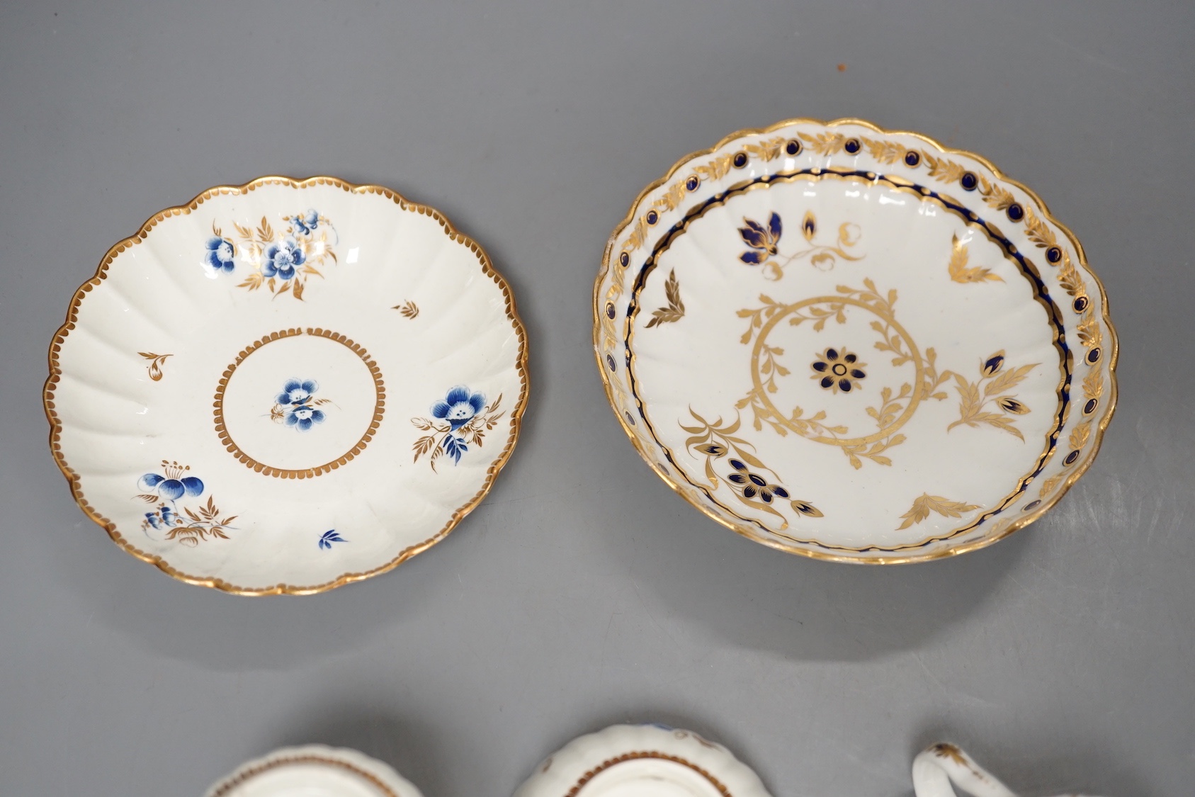 A Worcester fluted coffee cup, teacup and saucer painted with dry blue flowers and gilt foliage and a fluted coffee cup and saucer with blue and gilt decoration c.1775 and later